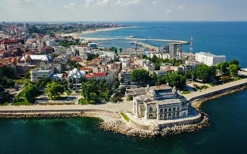 Luftaufnahme einer Küstenstadt mit historischem Gebäude am Meer.