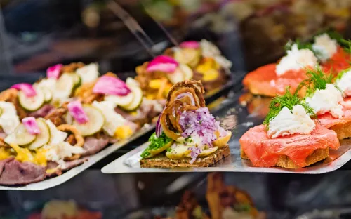 Auslage mit verschiedenen Canapés, darunter Lachs und Gemüse.