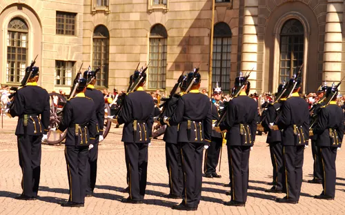 Soldaten in Uniform vor einem historischen Gebäude, Rücken zur Kamera.