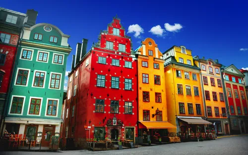 Bunte Fassaden historischer Gebäude in der Altstadt von Stockholm, Schweden, bei klarem Himmel.