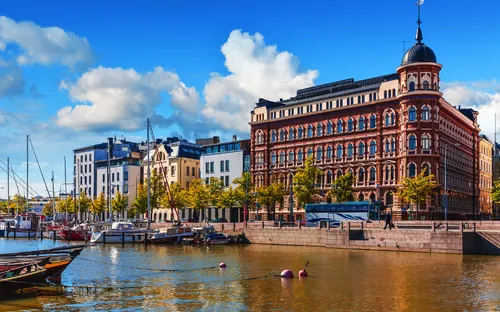 Hafen mit gemauerten Gebäuden und Booten unter blauem Himmel.