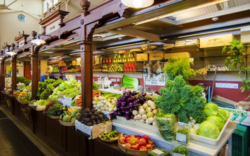 Ein Marktstand mit frischem Obst und Gemüse in einer Markthalle.