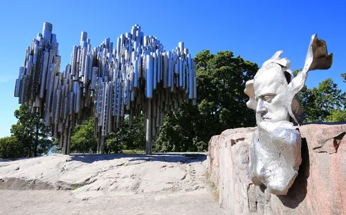 Sibelius-Denkmal in Helsinki, Finnland an einem sonnigen Tag. Im Hintergrund sind Bäume zu sehen.