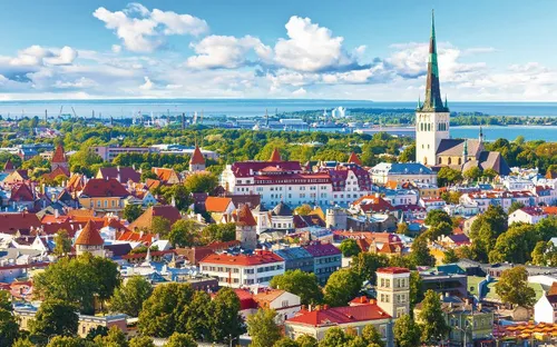 Stadtansicht mit bunten Gebäuden und einer Kirche im Hintergrund.