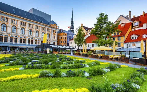 Historische Gebäude mit bunten Fassaden umgeben von gepflegten Gärten und Terrassen.