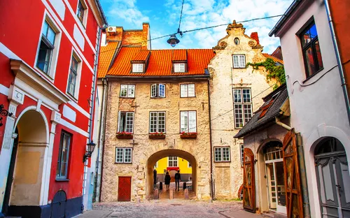 Altstadtgasse mit historischen Gebäuden und einem Torbogen.