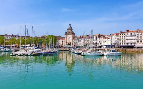 Hafen mit Segelbooten und historischer Turm in der Altstadt bei sonnigem Wetter