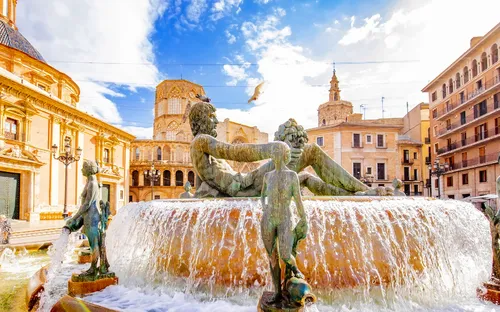 Springbrunnen mit Skulpturen in historischer europäischer Stadt.