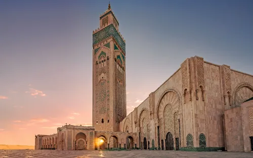 Große Moschee bei Sonnenuntergang mit Mosaikverzierungen und Minarett.