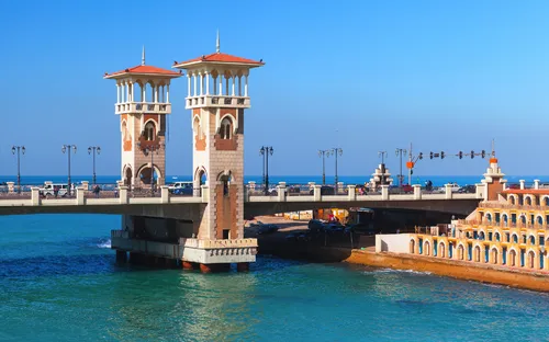 Brücke mit zwei Türmen über blauen Fluss unter klarem Himmel.