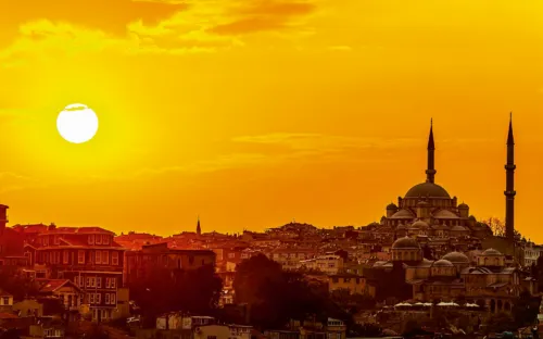 Sonnenuntergang über der Skyline von Istanbul mit einer Moschee und Minaretten im Vordergrund.