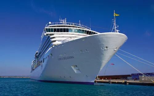 Kreuzfahrtschiff im Hafen mit klarem Himmel im Hintergrund.