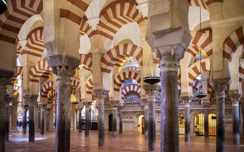 Innere der Mezquita-Catedral mit roten und weißen Bögen und Marmorsäulen.