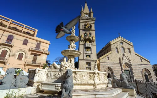 Kathedrale von Messina mit Brunnen und Taube im Flug.