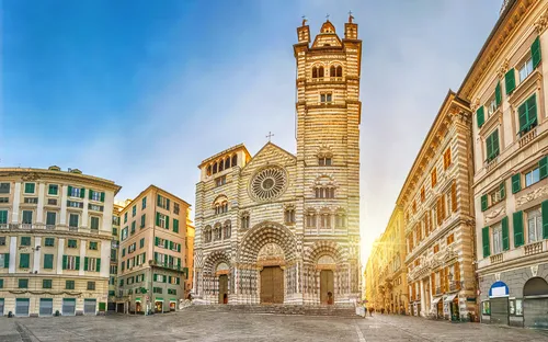 Historische Kathedrale mit weißen und grauen Streifen auf einem leeren Platz bei Sonnenuntergang.