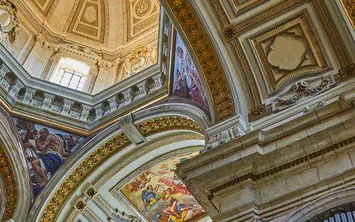 Innenansicht einer reich verzierten Kuppel mit Fresken und Architekturdekor.