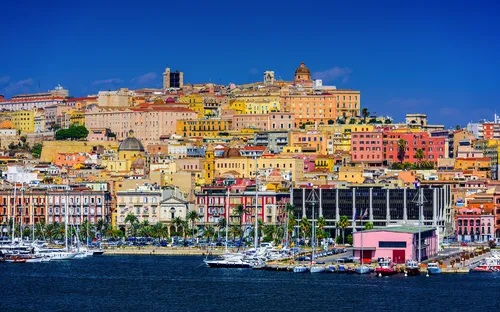 Blick auf eine bunte Stadt am Meer mit Hafen und Booten.