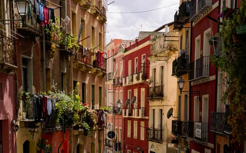 Straße in Cagliari auf Sardinien mit bunten Gebäuden und Balkonen voller hängender Wäsche.