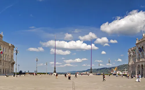 Historischer Platz mit großen Gebäuden und blauem Himmel.