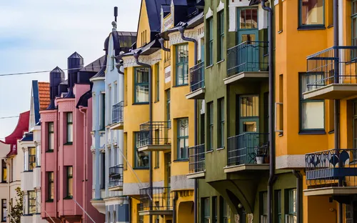Bunte Häuserfassade mit Balkonen in einer Stadtstraße.