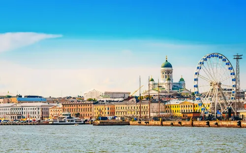 Stadtansicht von Helsinki mit Riesenrad und Dom am Hafen.