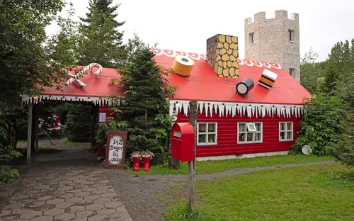 Lebkuchenhaus mit rotem Dach und Süßigkeiten darauf im Wald.