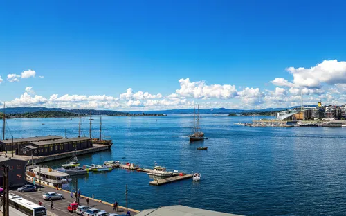Panorama eines Hafens mit Kreuzfahrtschiff und Stadt im Hintergrund.