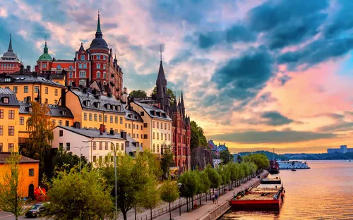 Bunte Gebäude am Wasser bei Sonnenuntergang in einer europäischen Stadt.