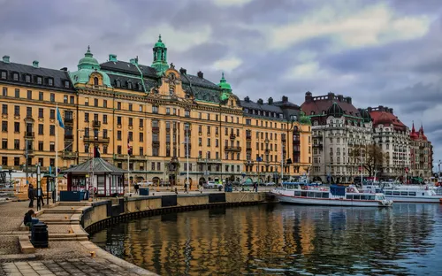 Hafenbecken in Stockholm mit historischen Gebäuden am Ufer und einigen Booten im Wasser.