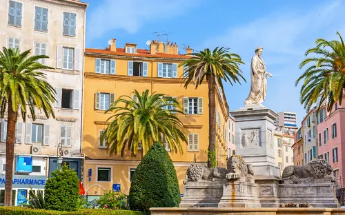 Statue von Napoleon in Ajaccio auf Korsika umgeben von Palmen.