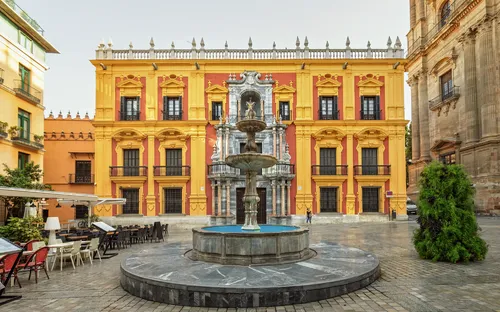 Springbrunnen vor einem historischen Gebäude auf einem Platz.