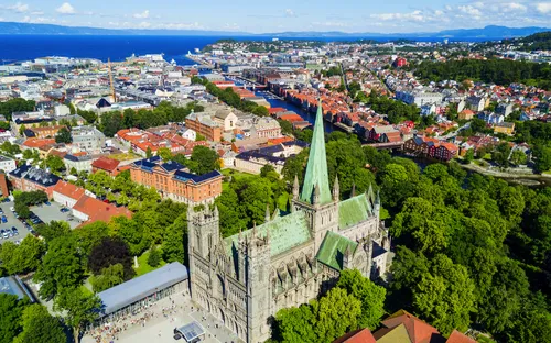Luftaufnahme einer Stadt mit einer großen Kathedrale und umliegender grüner Landschaft.