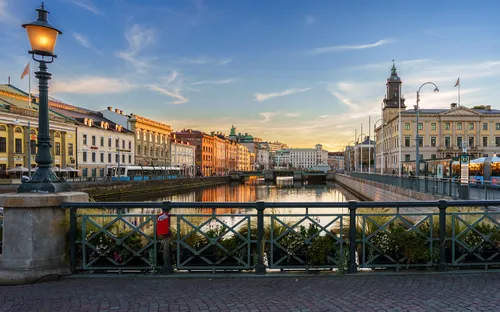 Städtischer Kanal mit Brücke und historischen Gebäuden bei Sonnenuntergang.