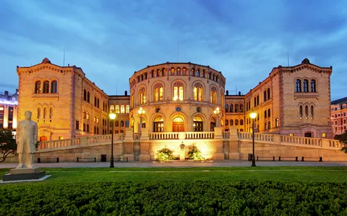 Historisches Gebäude bei Dämmerung, beleuchtet von Straßenlaternen.