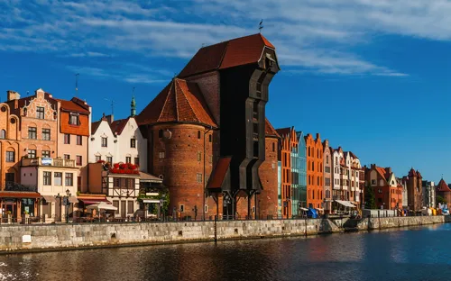 Historischer Krantor in Danzig, an einem sonnigen Tag am Wasser.