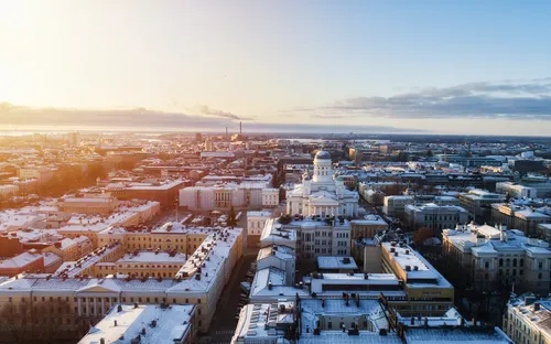 Luftaufnahme einer Stadt bei Sonnenaufgang mit Gebäuden im Schnee.