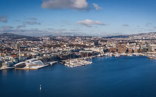 Luftaufnahme einer Stadt mit Hafen und modernen Gebäuden am Wasser.