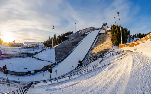 Skisprungschanze bei Sonnenuntergang im Winter.